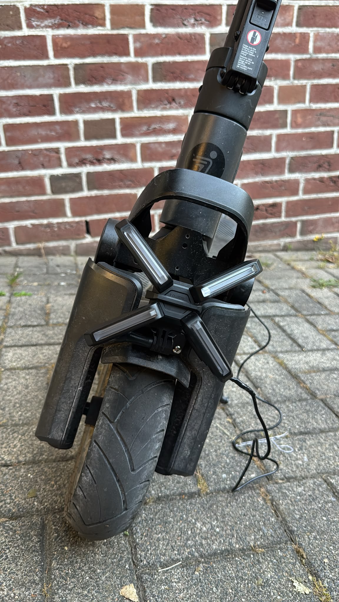 X-Licht E-Scooter Frontbeleuchtung mit universeller Halterung vor Ziegelwand, für alle Modelle